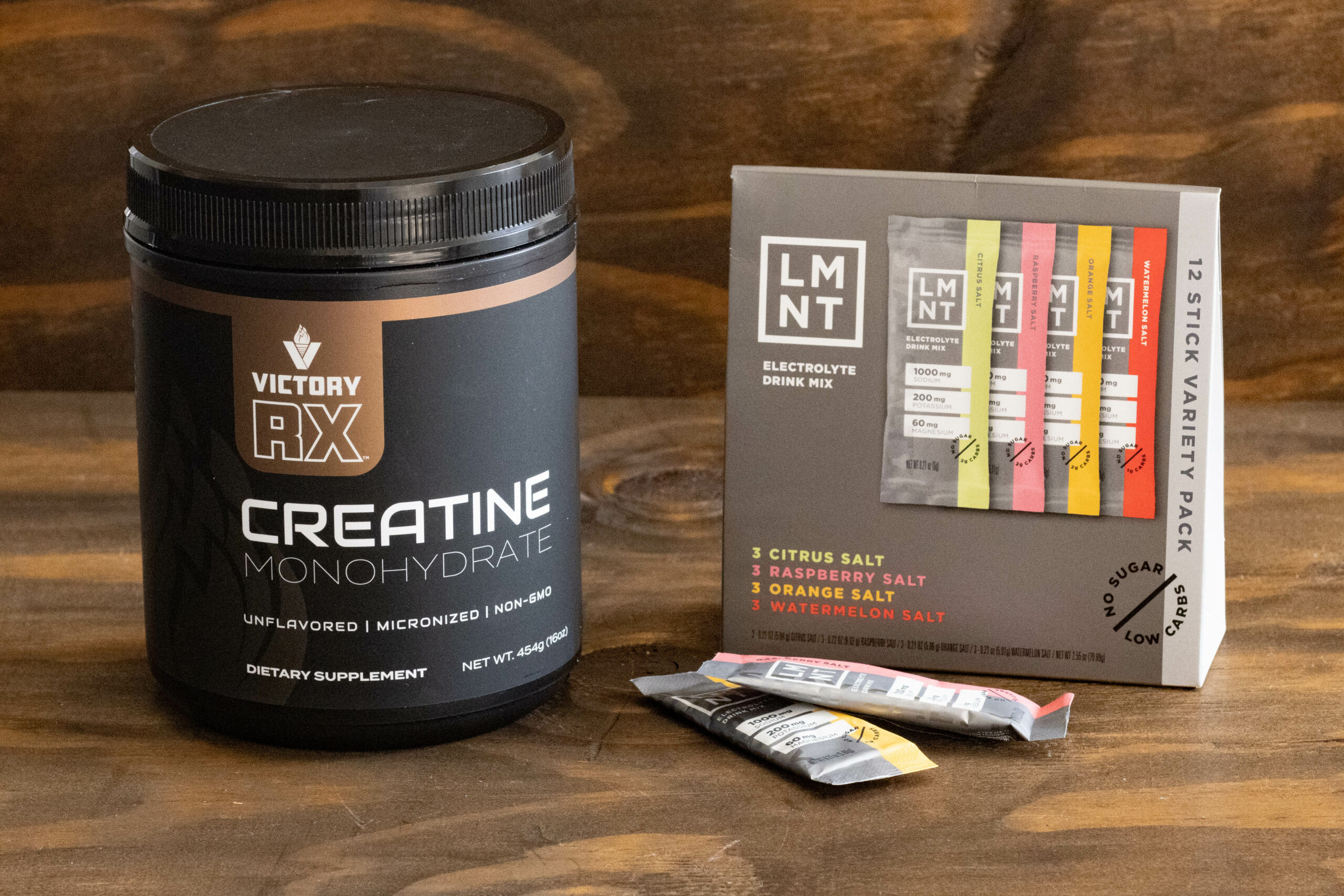 Creatine for women supplement sitting on a table next to LMNT nutritious drink mixes.